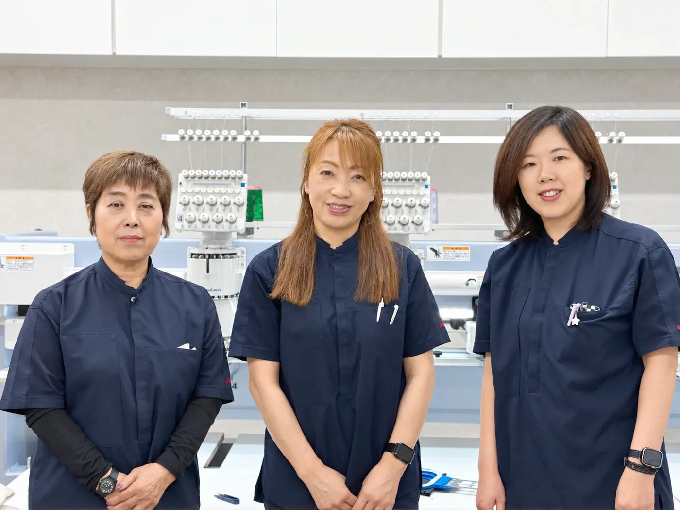 岡山の自社工場で業務用刺繍機に向かう加工スタッフ